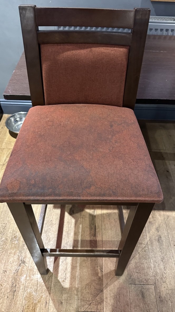 A venue bar chair before cleaning by Jay's Cleaning, the seat dark and mottled with years of ground-in grime