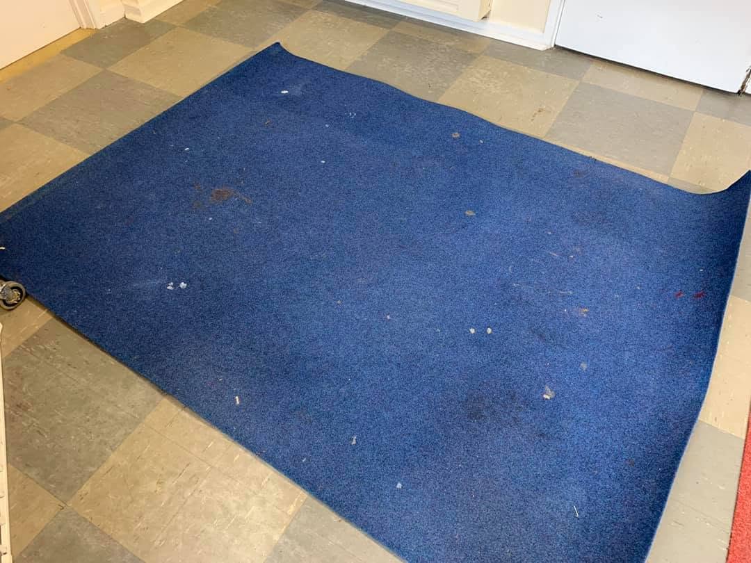 The same rug before cleaning — soiled and marked