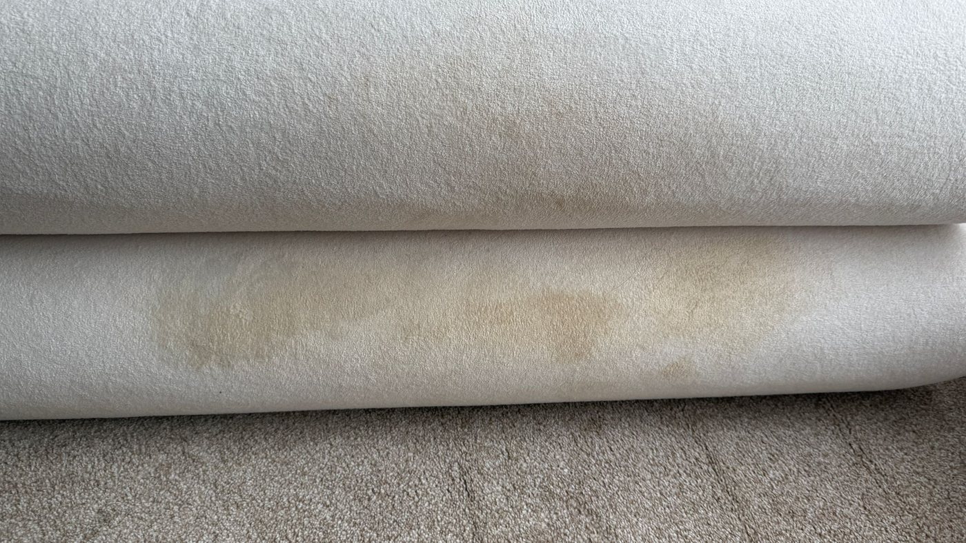 A tea stain dried into a cream sofa cushion before cleaning